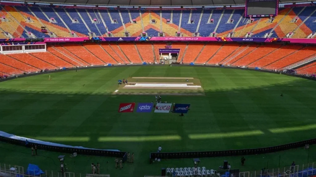 Promotional landscape image for the ICC T20 World Cup 2026 showing India vs Namibia at Arun Jaitley Stadium, New Delhi. Includes Indian and Namibian players, cricket stadium under lights, pitch report with batting-friendly surface, early pacer swing, evening dew factor, weather forecast of 19–25°C, and target score 165–180 runs.
