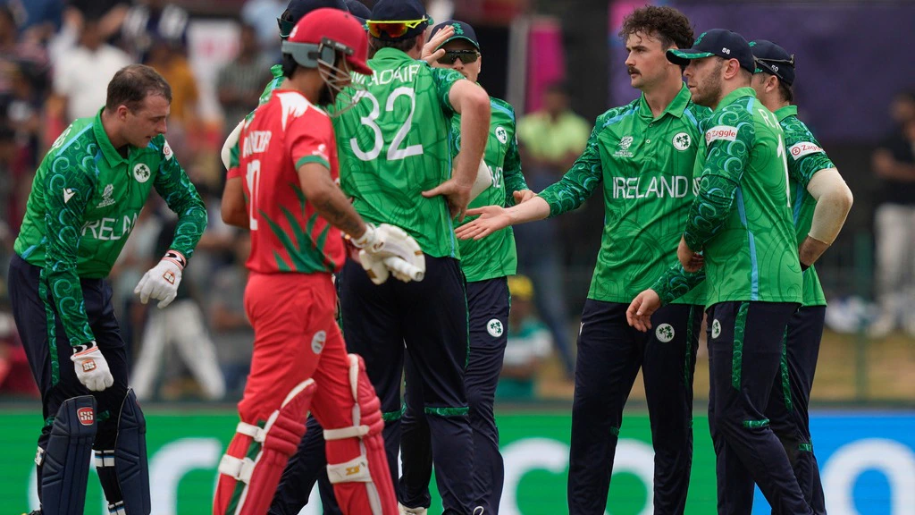 Ireland cricket team celebrates their 96-run victory over Oman at the Sinhalese Sports Club Ground in Colombo, with the scoreboard displaying the final match result.